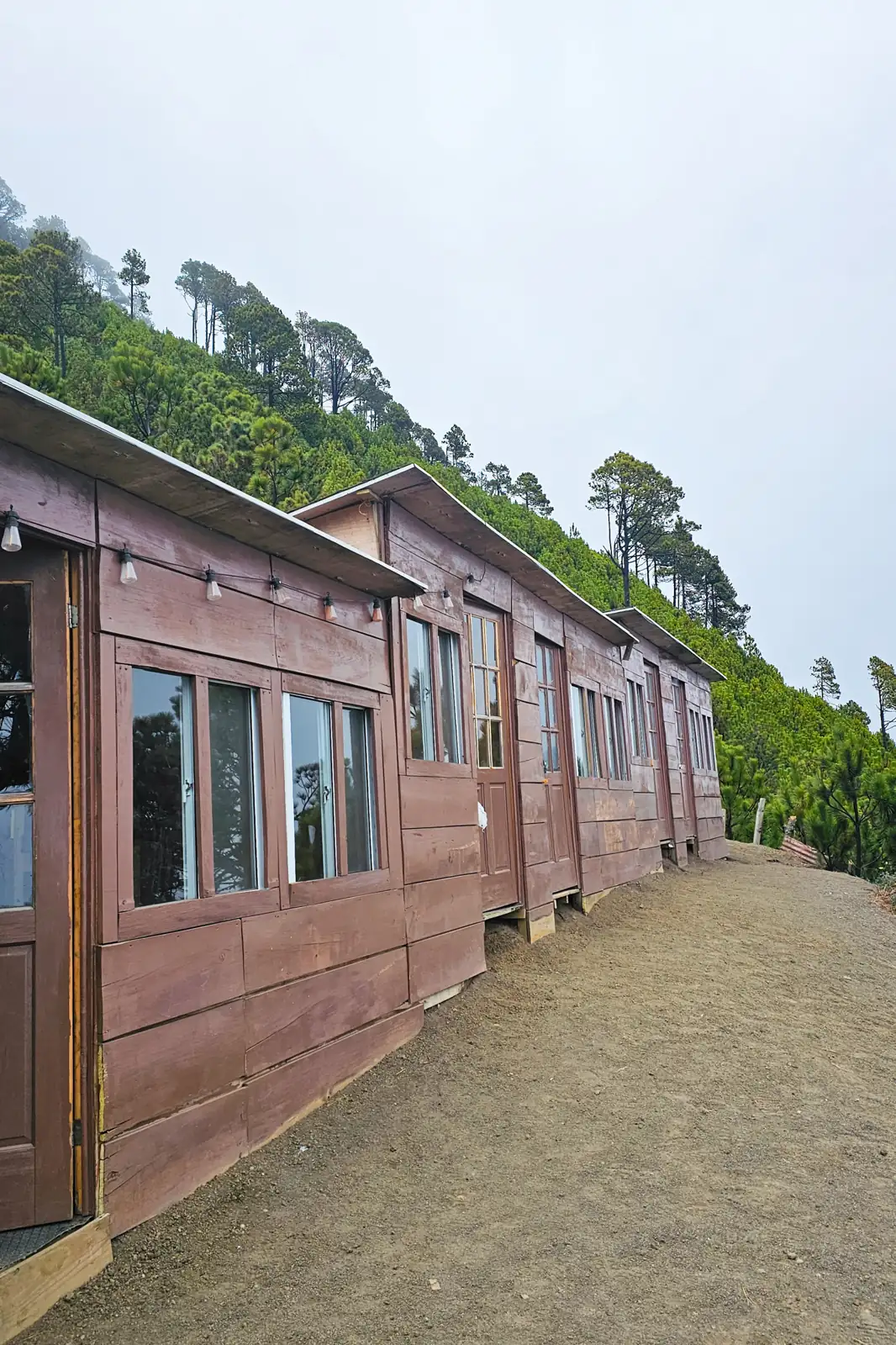 Wooden A-frame cabins at Acatenango base camp above the clouds