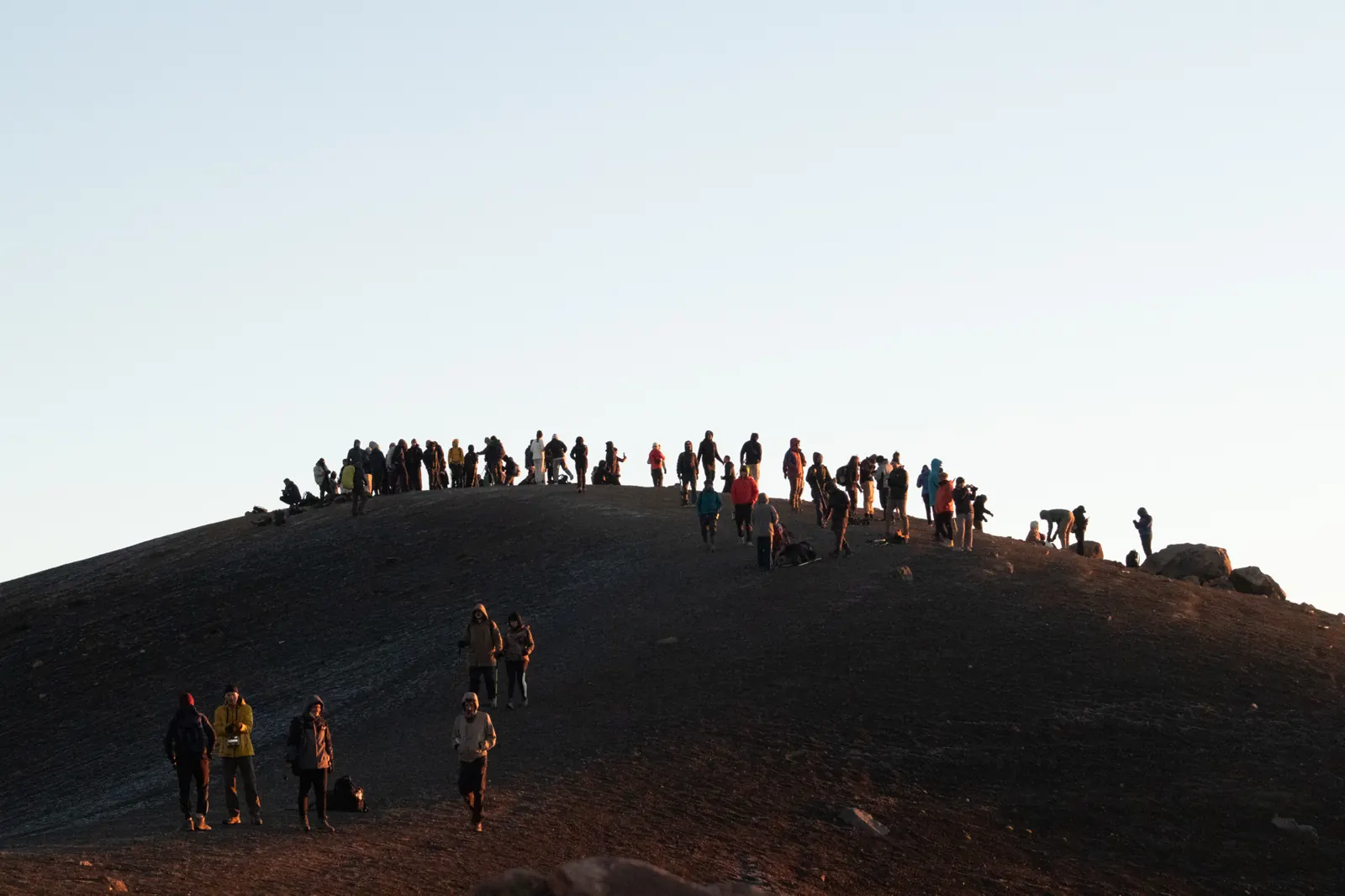 Group of hikers gathered on the Acatenango summit at sunrise