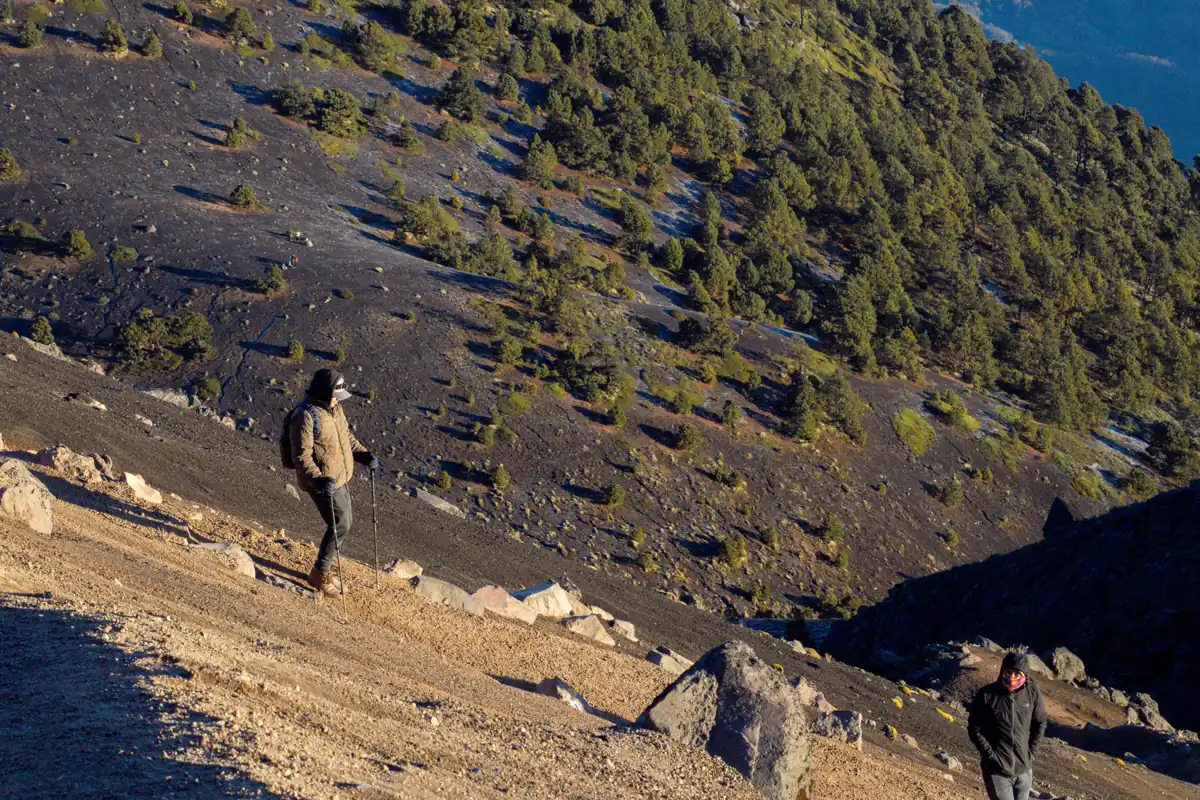 Hiker ascending the loose volcanic scree on Acatenango